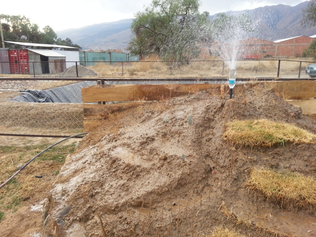 An unconvential use of the containers themselves - as a fence for the Center for Ecological Agriculture (CEA) (back left corner). In the foreground is a dirt mound at the CEA demonstrating the difference using terraces makes in managing water flow and preventing erosion.